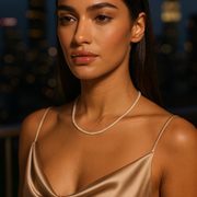 Woman wearing a gold dress in small beaded necklace against a blurred background