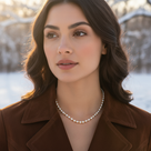 Woman wearing a pearl necklace with a snowy landscape in the background